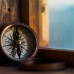 Compass against a wooden window frame.