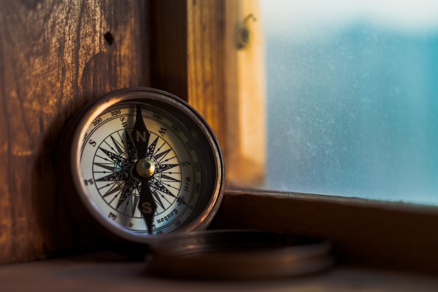 Compass against a wooden window frame.